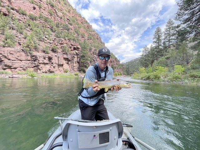 Angler holding a trout from a guided float trip
